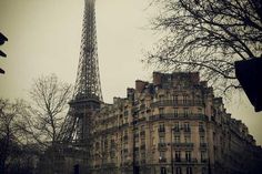 the eiffel tower in paris, france is seen from across the street on a foggy day