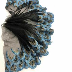 a blue and black scarf with feathers on it