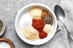 a bowl filled with different types of spices next to two bowls full of seasonings