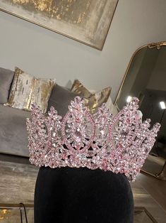 a pink tiara sitting on top of a mannequin's head in front of a mirror