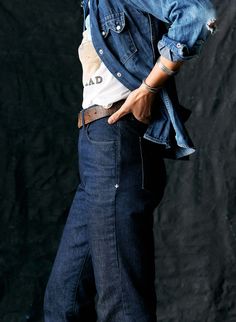 a man in blue jeans is posing for the camera