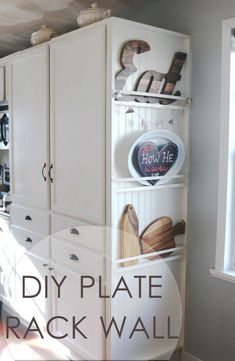 a kitchen with white cabinets and wooden cutting boards on the bottom shelf that says diy plate rack wall