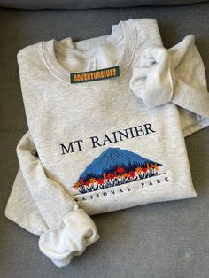 - Mount Rainier National Park Embroidered Hoodie - Perfect gift for nature lovers, adventurers, or anyone who loves National Parks.  - Fabrication - Heathered grey color crewneck - 70/20 cotton/poly blend - Size is unisex - Care Instructions - Turn inside out and machine wash cold on delicate cycle - Dry on low heat setting - Do not bleach or dry clean - Processing and Shipping Times - Please allow 3-5 business days for your order to be processed and stitched - Standard shipping takes 3-5 days - National Parks Gift Ideas, Mountain Clothes, State Embroidery, National Park Sweatshirt, Crewneck Aesthetic, Trendy Sweatshirts, Hamster Wheel, Clothes Embroidery Diy, Mount Rainier National Park