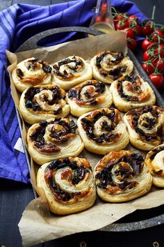 there are many rolls on the pan ready to be eaten with cherry tomatoes in the background