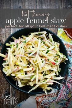 an apple salad in a black bowl on top of a wooden table with text overlay that reads, not honey apple fennel slaw perfect for all your fall meat dishes