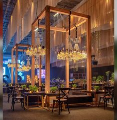 an indoor dining area with chandeliers hanging from the ceiling