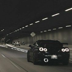 a black car driving through a tunnel with two eyes on it's front end