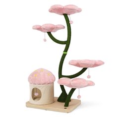 a plant with pink flowers on it next to a small doll house and other items