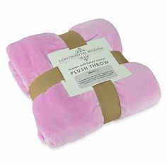 a pink and brown blanket sitting on top of a white surface with a tag attached to it