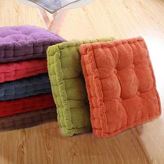 four folded towels sitting on top of a wooden floor