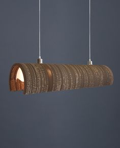 a wooden light fixture hanging from a ceiling with two lights on each side and an object in the middle