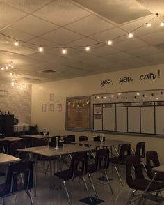 an empty classroom with desks and chairs in front of a chalkboard that says yes, you can