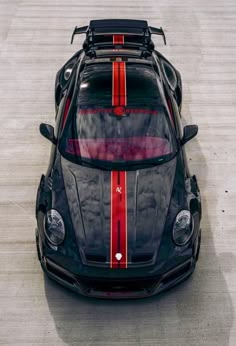 the front end of a black sports car with red stripes