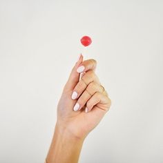 a woman's hand holding a candy lollipop