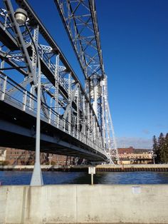 the underside of a metal bridge over a body of water