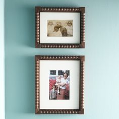 two framed pictures hang on the wall next to each other, one is holding a baby