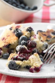 a white plate topped with blueberry cobbler next to a fork