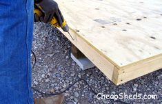 a person using a power drill to attach the plywood planks on top of a table