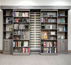 two bookshelves with many different types of books on them in an empty room