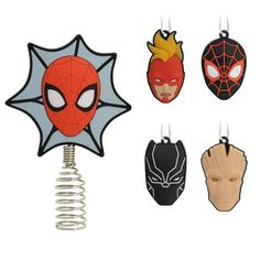 four different masks hanging from hooks on a white background with clippings attached to them