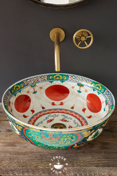 a bowl shaped sink sitting on top of a wooden table next to a wall mounted mirror