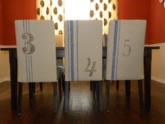 a dining room table with four chairs and the number thirteen printed on it's back