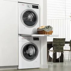 the front load washer and dryer are next to each other in this kitchen