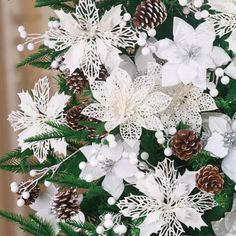 a christmas tree with white flowers and pine cones