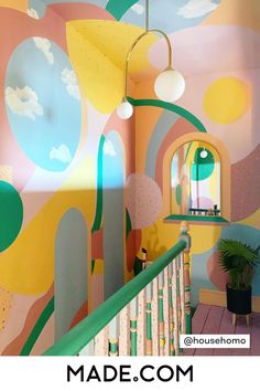 the interior of a house painted with colorful colors and shapes, including clouds and trees