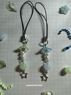 three necklaces with beads and charms hanging from it's sides on a table