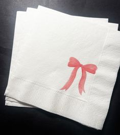 two napkins with pink bows on them