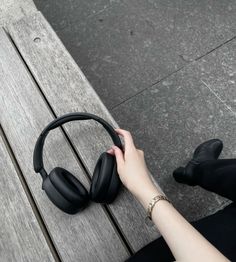 a woman is sitting on a bench with headphones