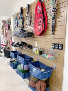 there are many sports items hanging on the wall in this room, including balls and rackets