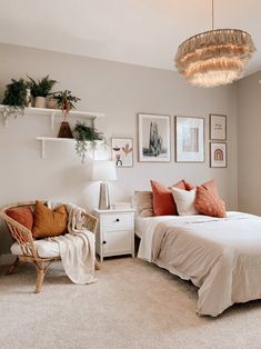 a bedroom with a bed, chair and pictures hanging on the wall above it's headboard