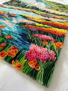 an image of a quilt made with flowers on the table top and in front of it