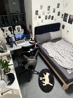 a bedroom with mickey mouse decorations on the wall and a bed in front of a laptop