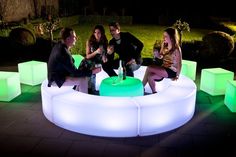 four people sitting around a lit up round table