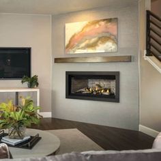 a living room with a couch, coffee table and television on the wall in front of it