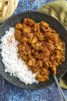 a plate full of chicken and rice on a blue table cloth next to some pita bread