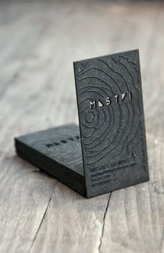 a business card sitting on top of a piece of black paper with the word msty printed on it