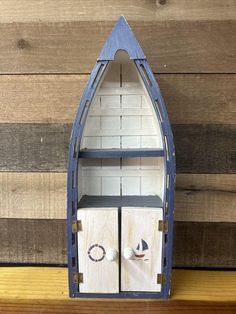 a boat shaped shelf with two doors on each side