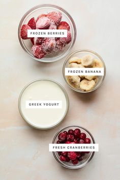 four bowls filled with fruit and yogurt on top of a table