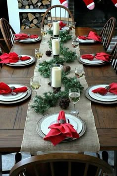 the table is set for christmas dinner with candles and napkins