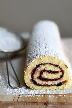 there is a roll that has been made with powdered sugar and raspberry