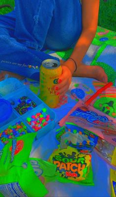 a person sitting at a table with some soda cans on it and other items in the background