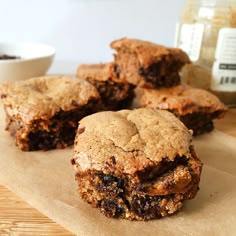 some cookies are sitting on a piece of paper next to a jar of peanut butter