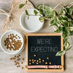 a sign that says we're expecting next to two bowls of food on a table