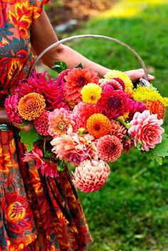 a woman holding a basket filled with colorful flowers