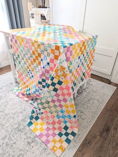 a quilted tablecloth on top of a rug in front of a white door