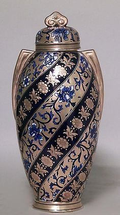 an ornate blue and gold urn with flowers on it's sides is shown